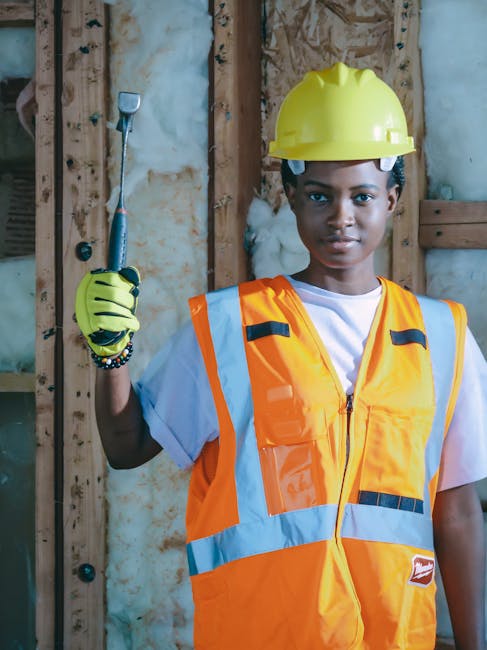 Darbininkas įrenginėja šilumos izoliaciją palėpėje virš lubų